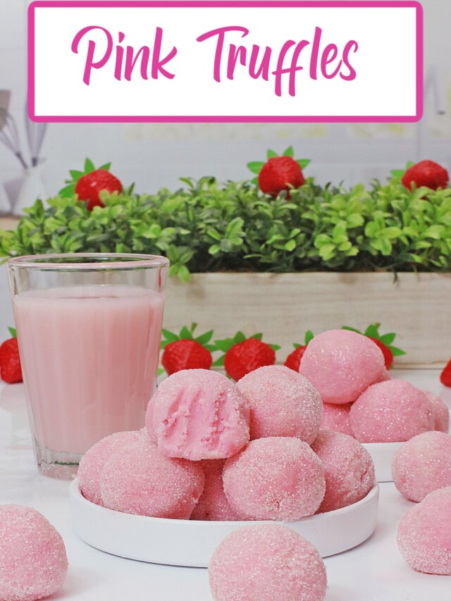 eight pink truffles stacked on a small white plate.
