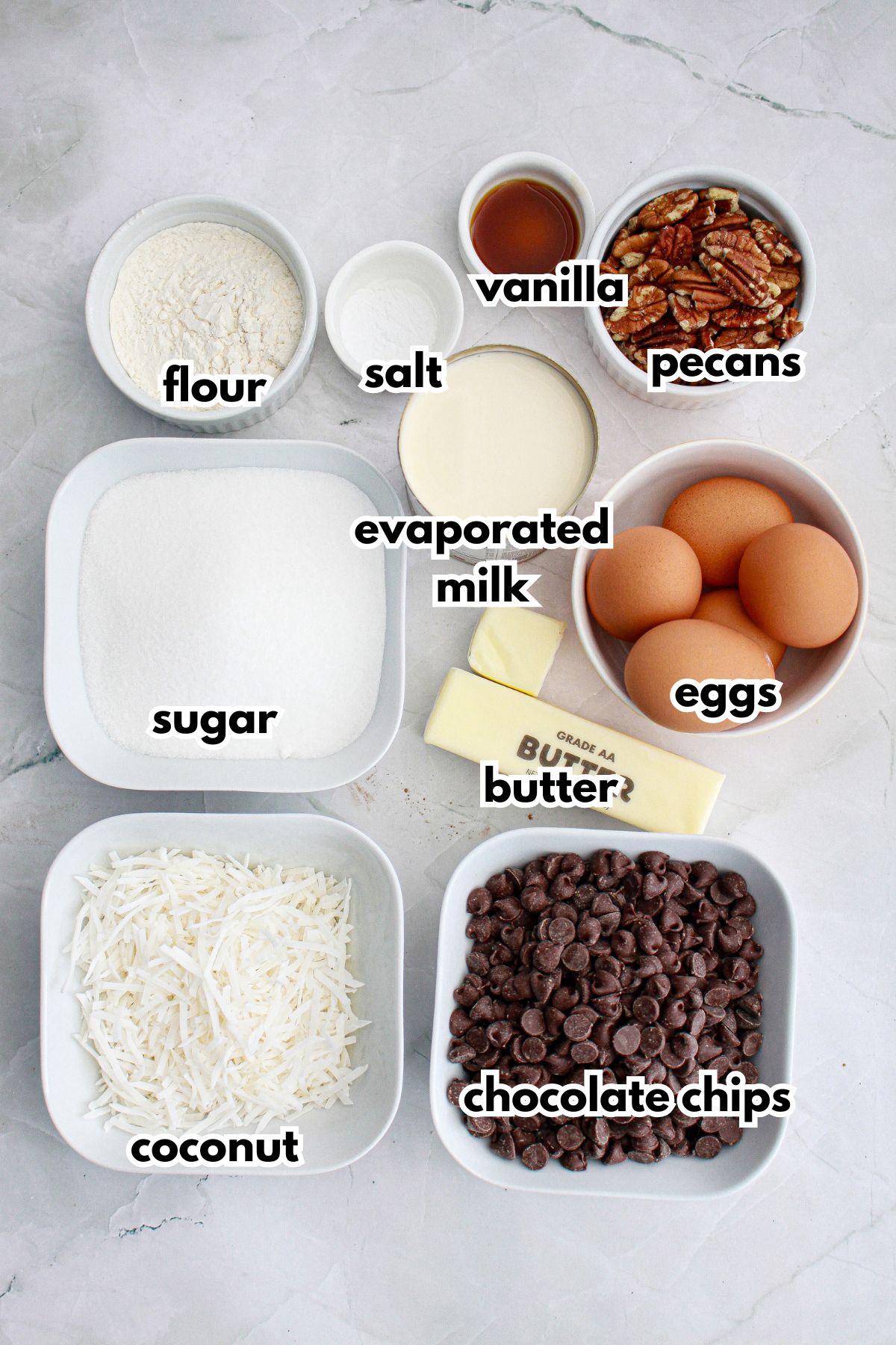 bowls of ingredients needed to make german chocolate cookies on a background.