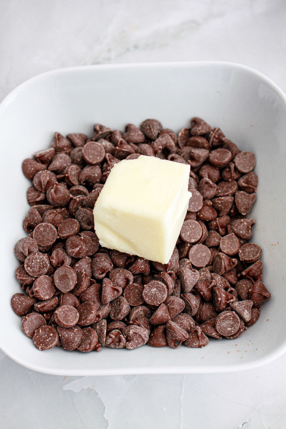 chocolate chips and butter being melted in a small bowl.