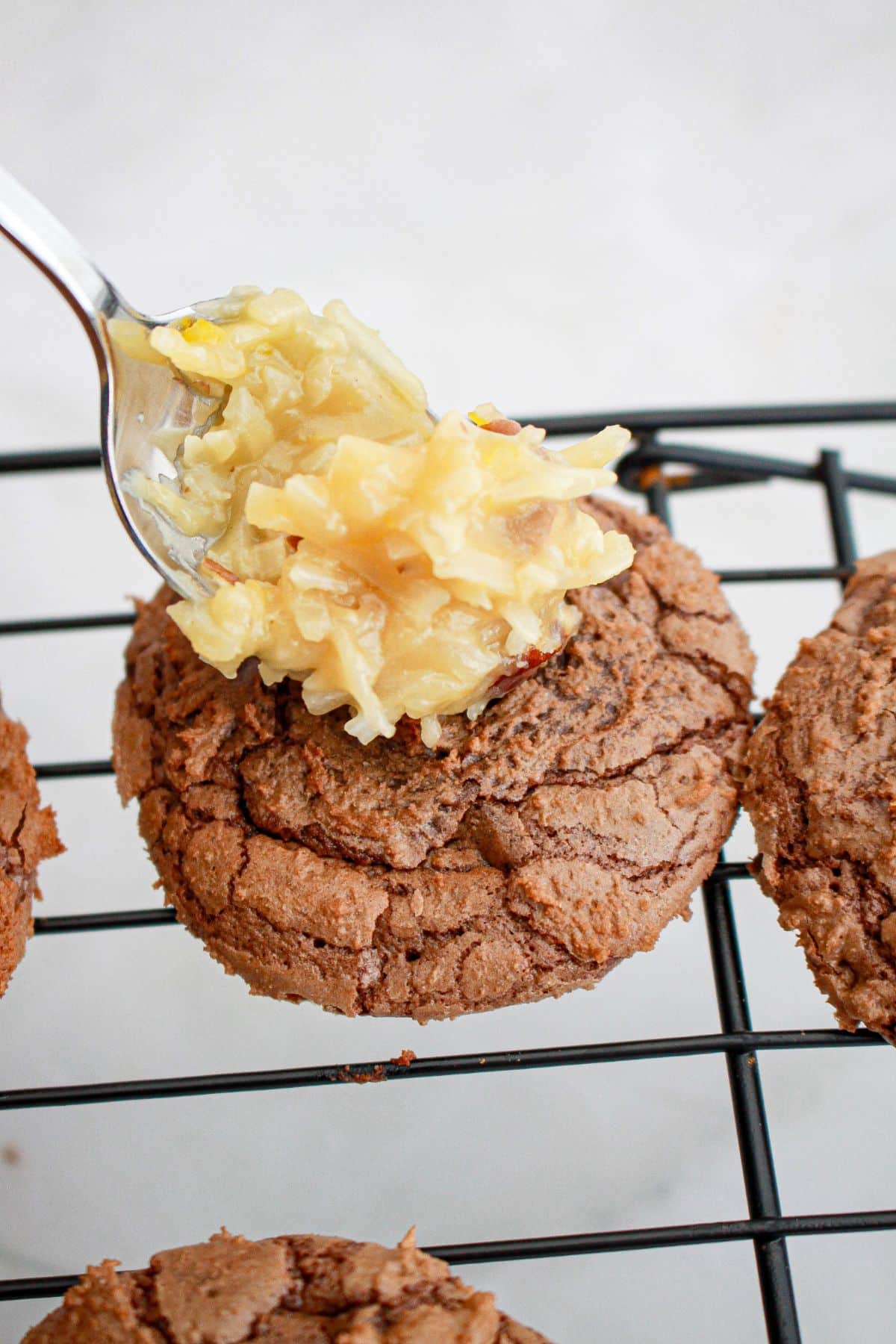 coconut mixture being put on top of cookies.