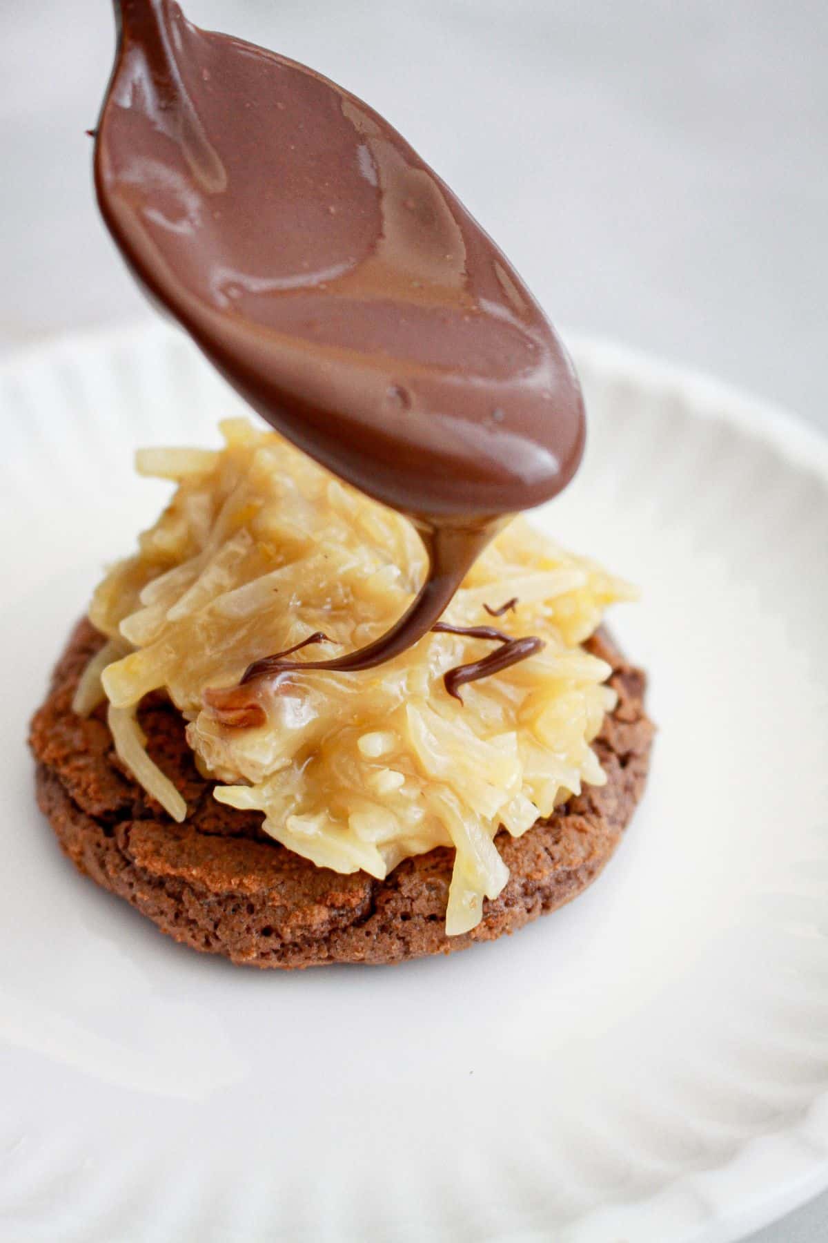 chocolate being drizzled on top of cookies.