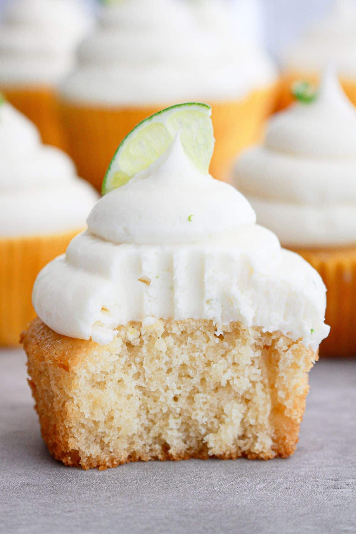 honey lime cupcake on a counter with a bite missing.