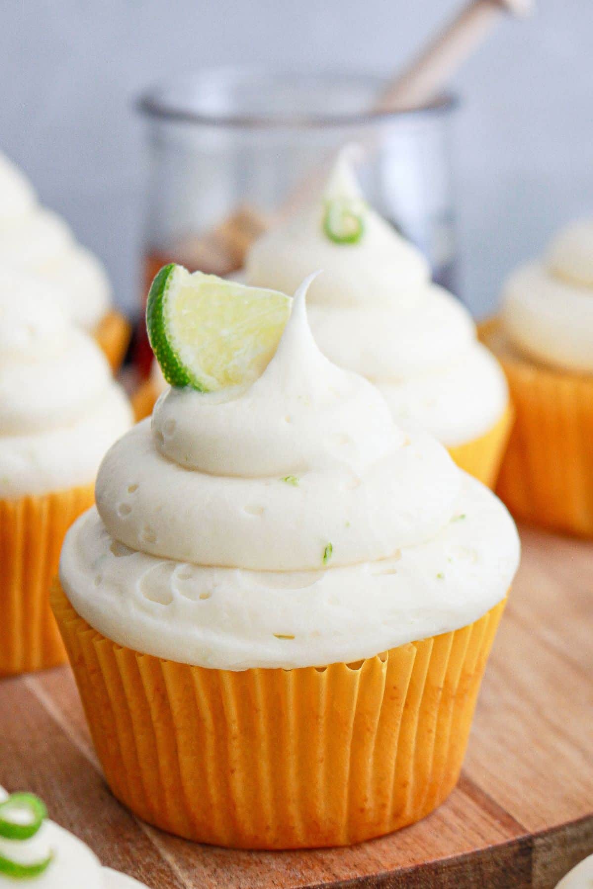 honey lime cupcakes on a wooden cutting board.