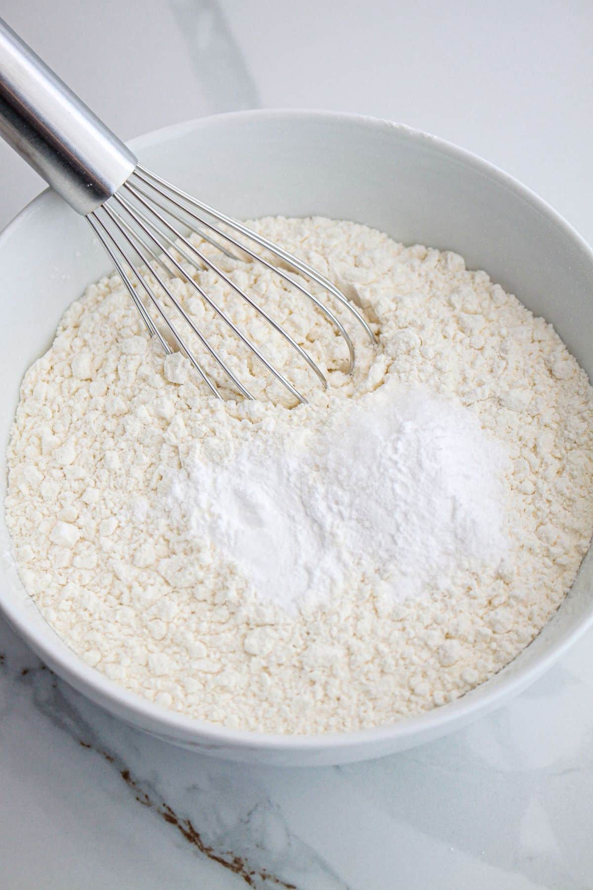 dry ingredients being whisked together in a mixing.