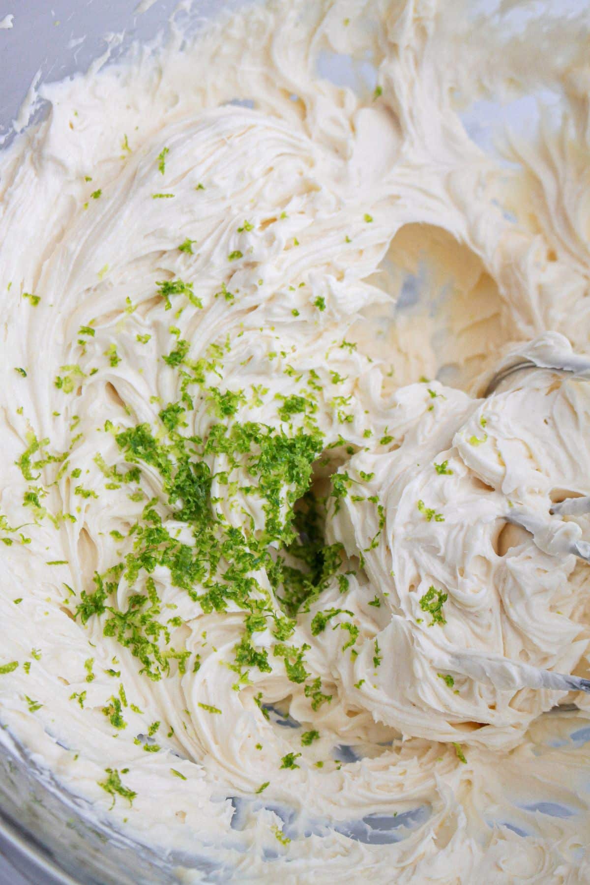 lime zest being added to the frosting.