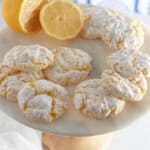 lemon cool whip cookies on a cake stand with a lemon.