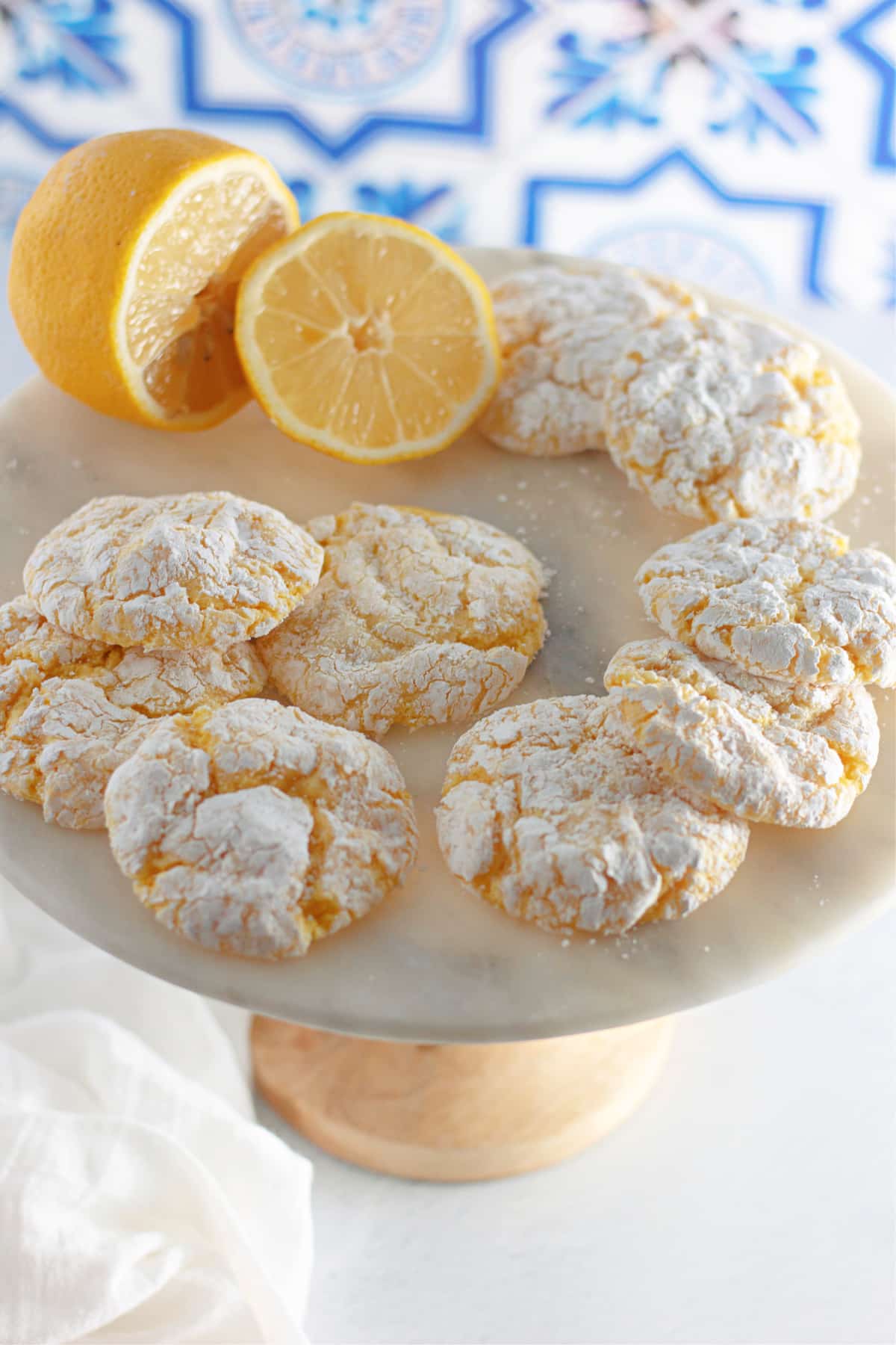 lemon cool whip cookies on a cake stand with a lemon.