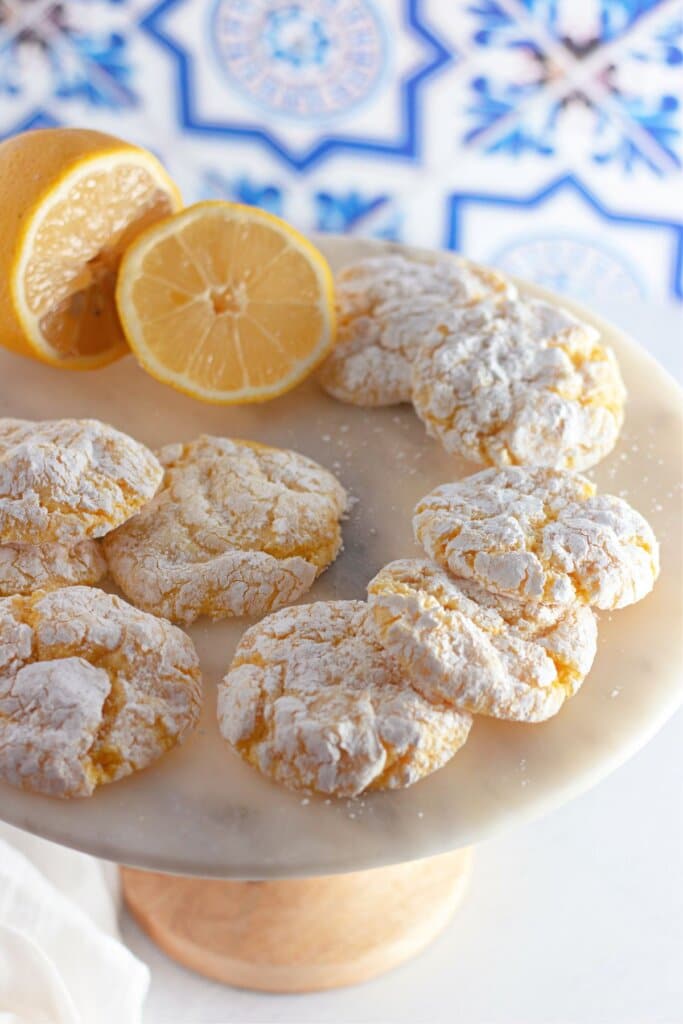 lemon cool whip cookies on a cake stand with a lemon.