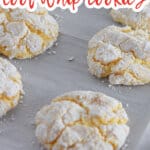 lemon cool whip cookies cooling on a parchment lined baking sheet.