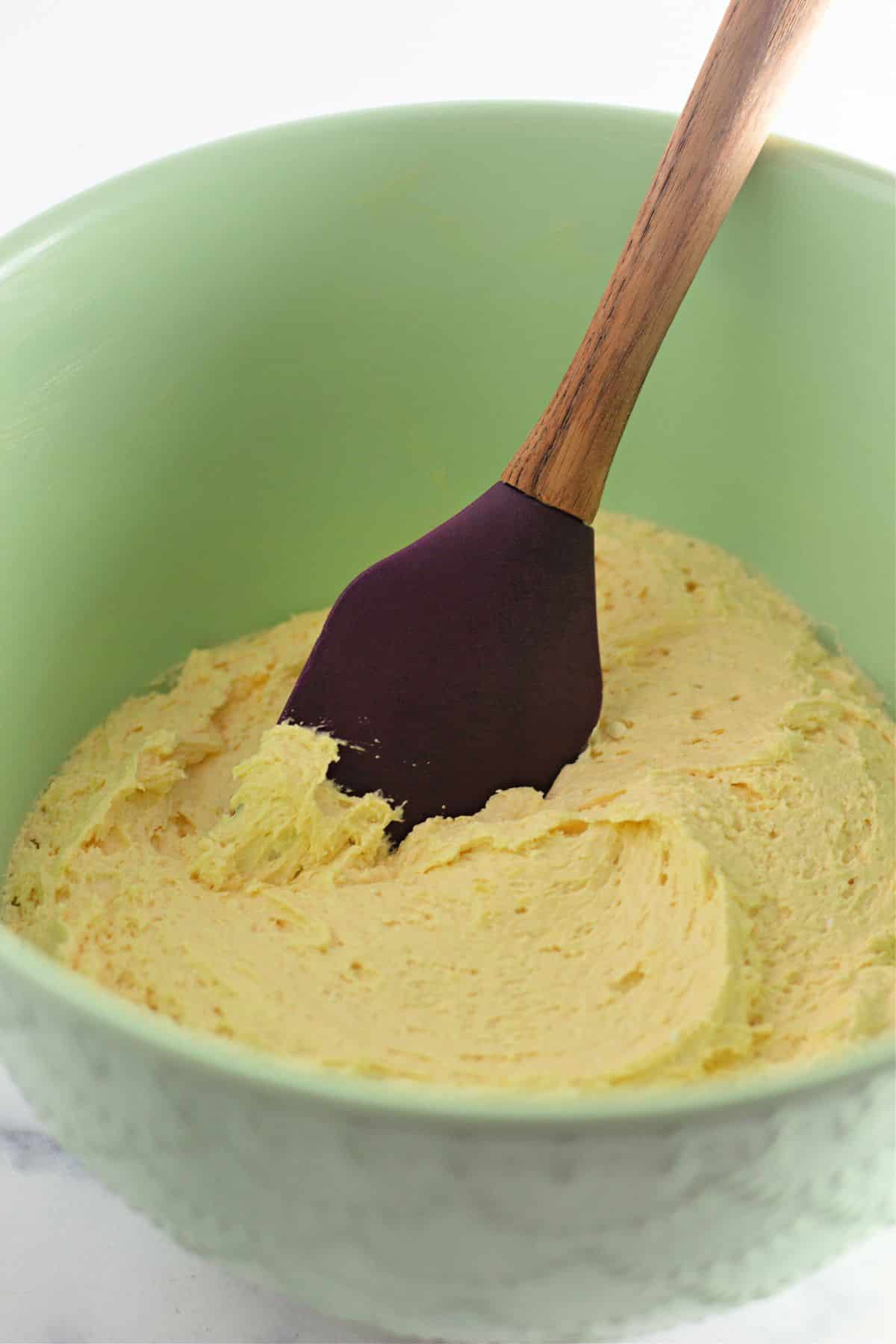 dough being mixed with a rumper spatula in a large mixing bowl