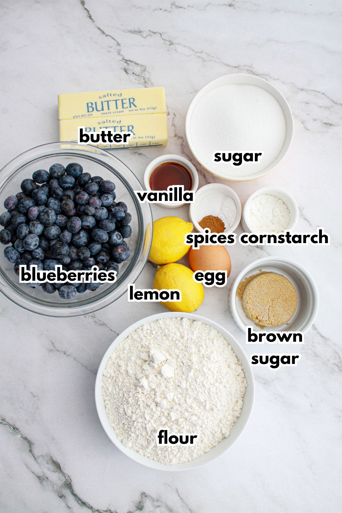 bowls of butter, blueberries, lemon, egg, vanilla, sugar, spices, cornstarch, flour and brown sugar.