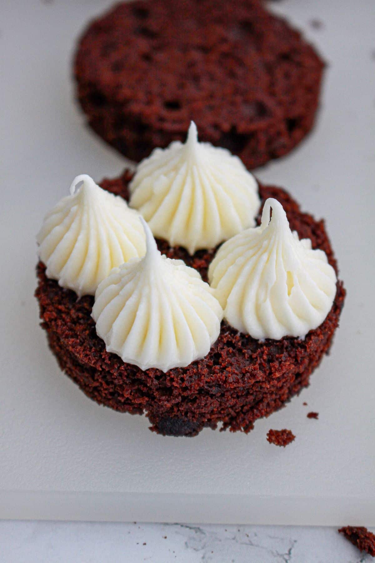 cream cheese icing being piped on a top of a round.