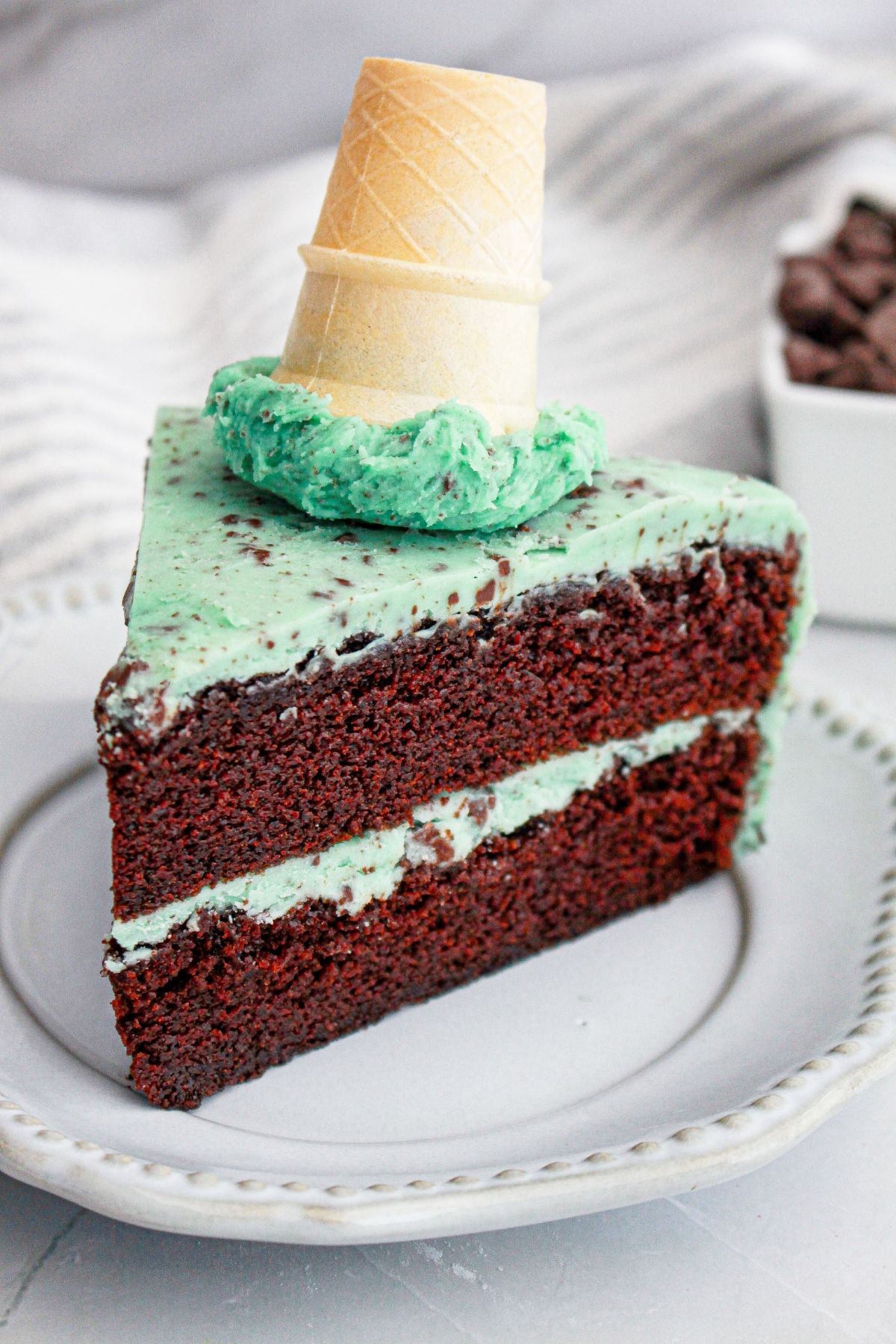 Slice of mint chocolate chip cake on a small plate.