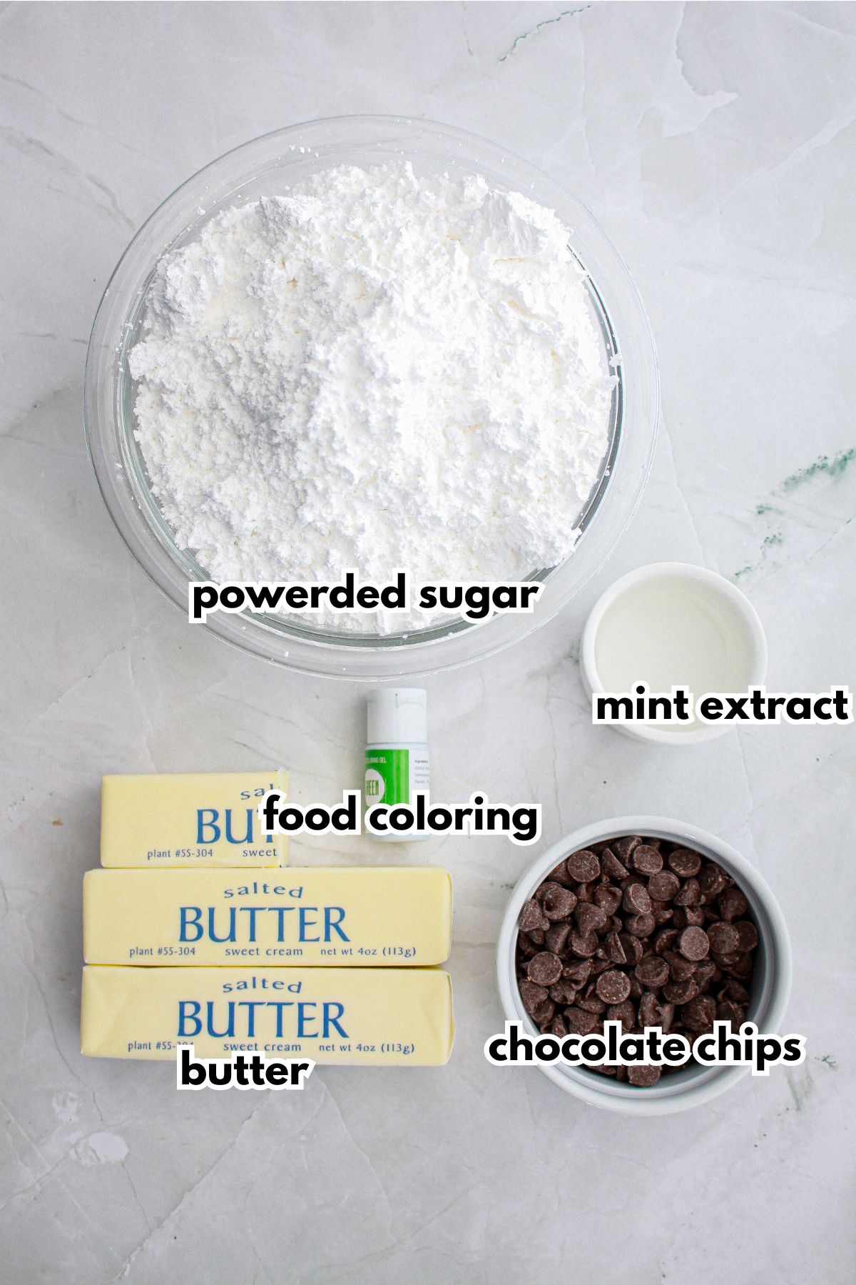 bowls of powdered sugar, butter, food coloring, chocolate chips, and mint extract.