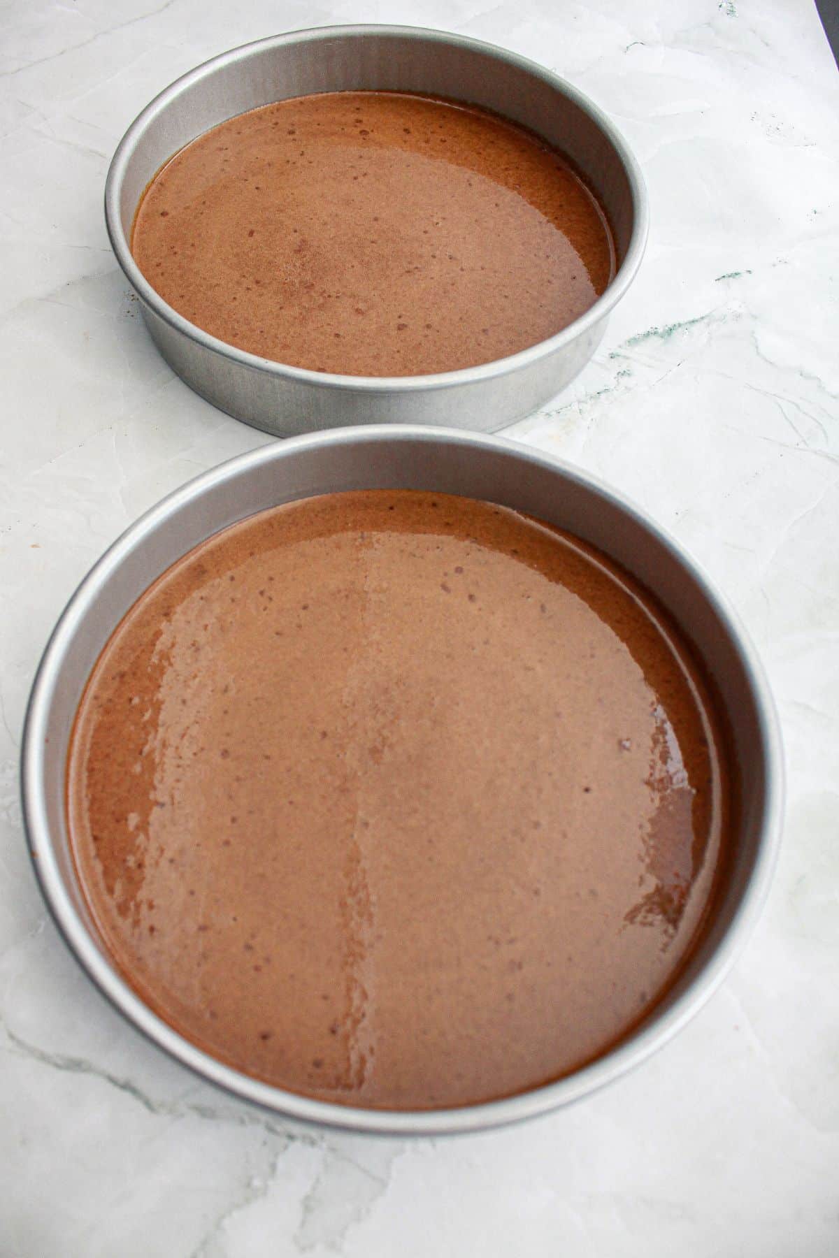 chocolate cake batter in two round cake pans.