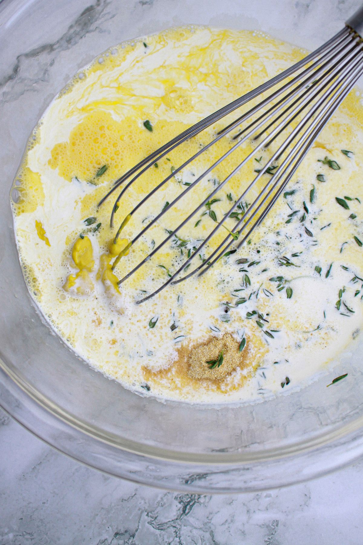 custard being mixed with a whisk in a large bowl.