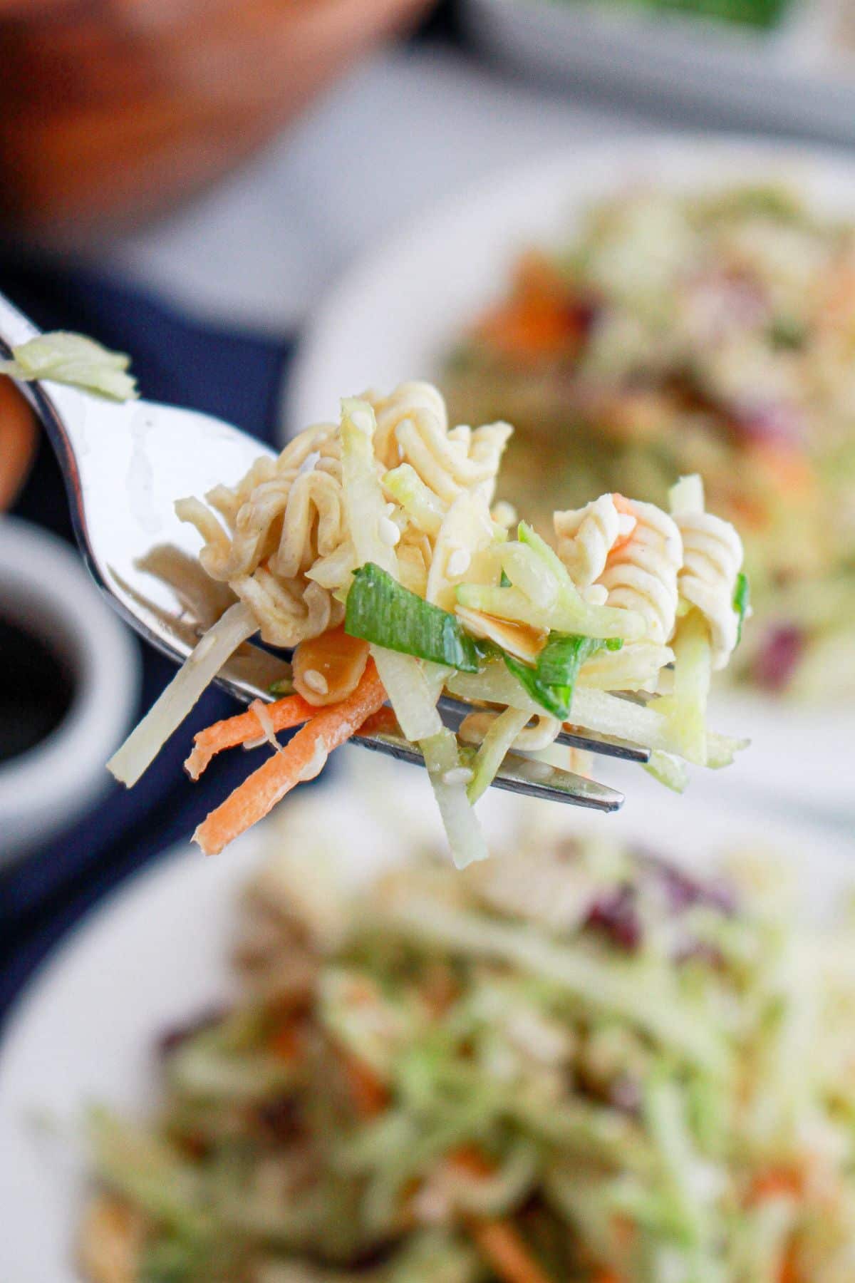 bite of oriental salad on a fork held in the air.