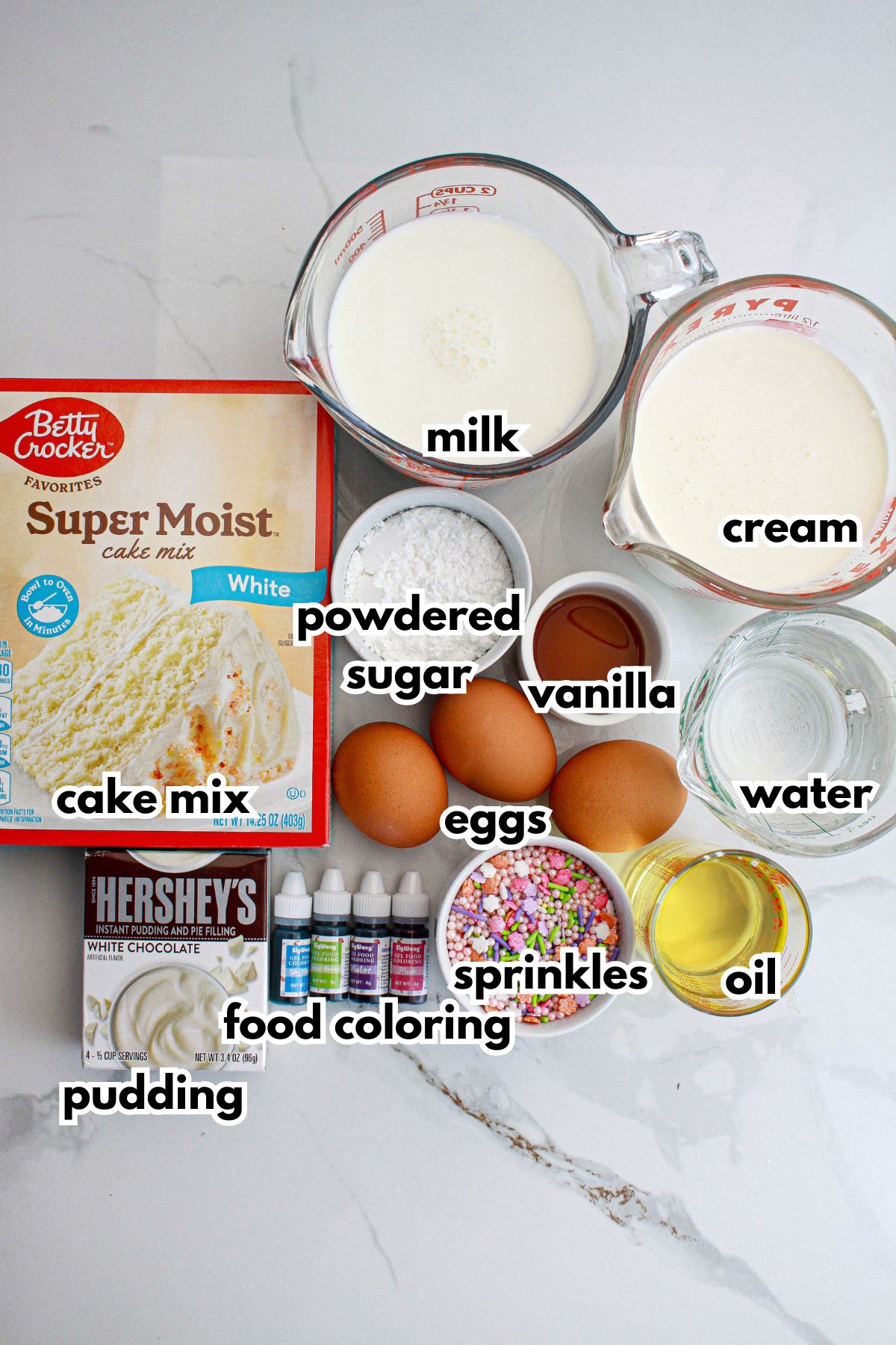 cake mix, milk, cream, powdered sugar, vanilla, water, eggs, sprinkles, oil, food coloring, pudding, on the counter.