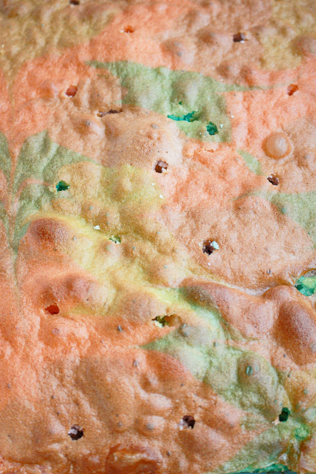 holes being punched into a cake in a baking dish.
