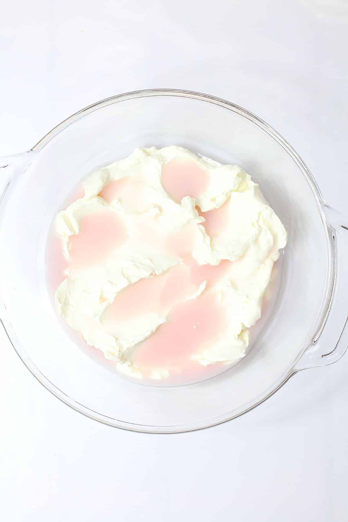 starbucks pink drink being added to whipped cream in a mixing bowl.