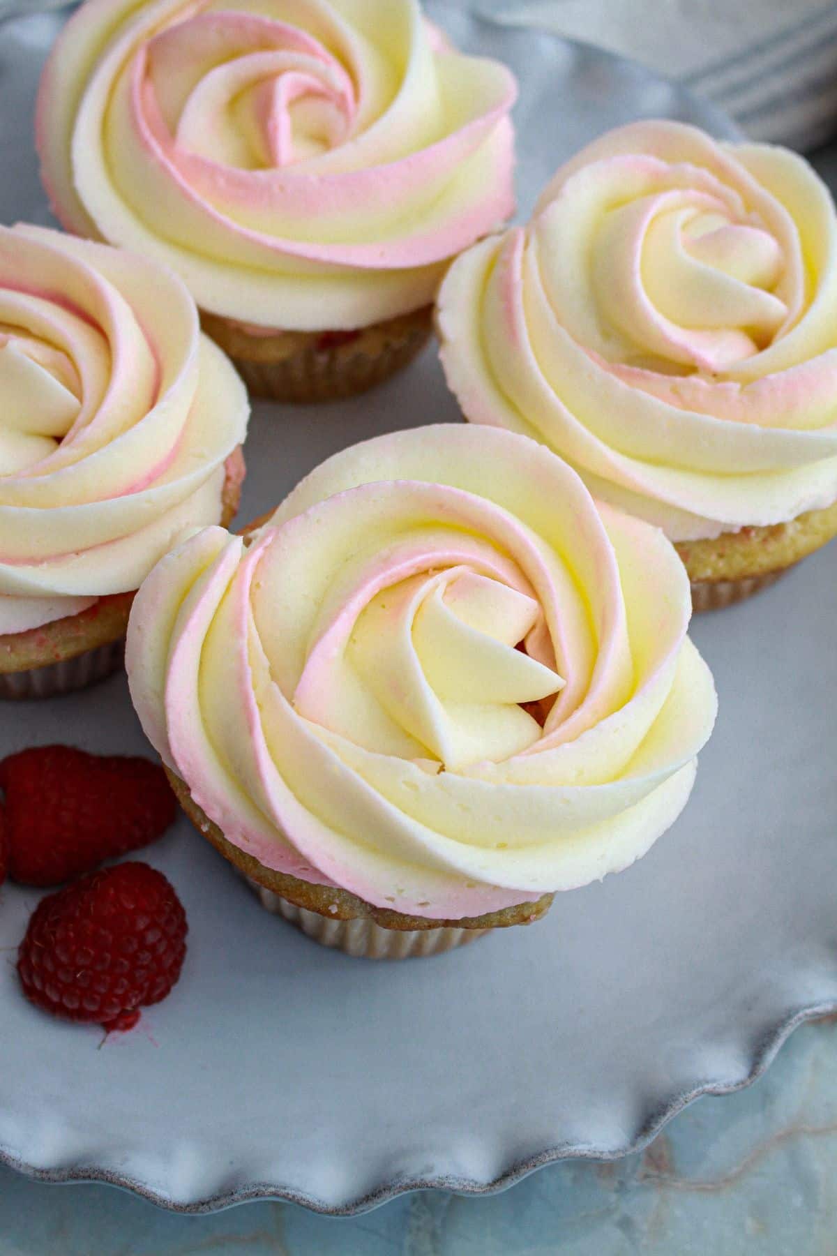 raspberry white chocolate cupcakes on a cake stand.