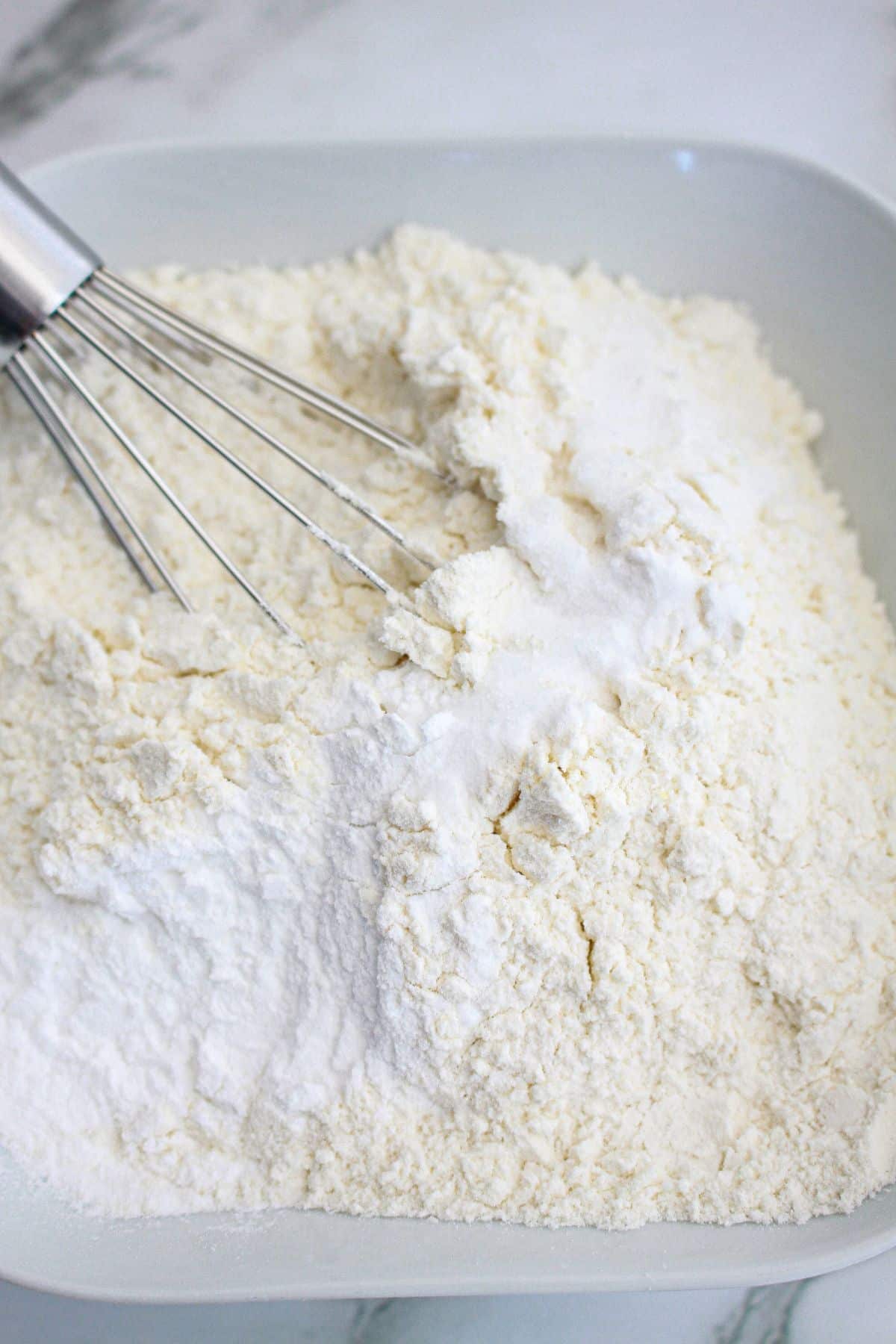 dry ingredients being mixed together in a bowl.