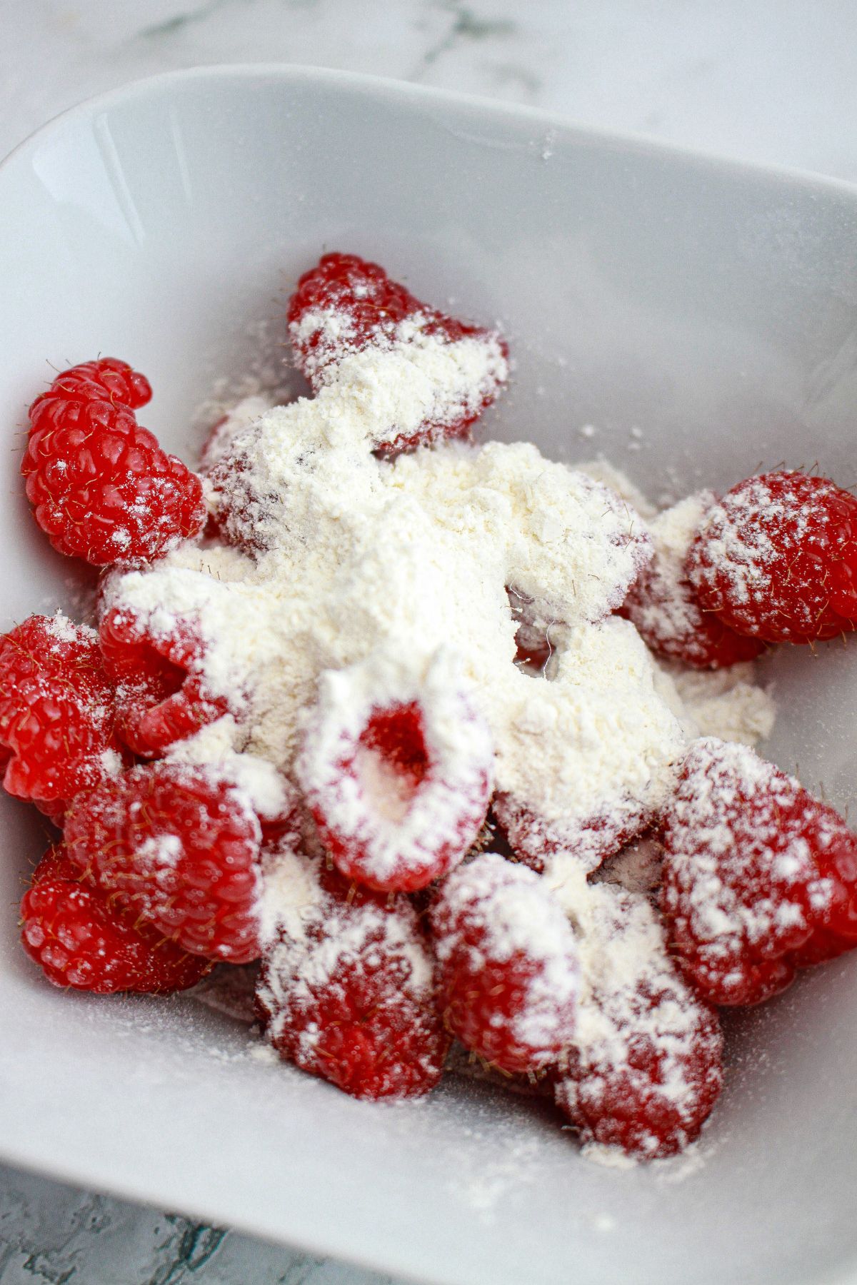 raspberries being dusted flour.