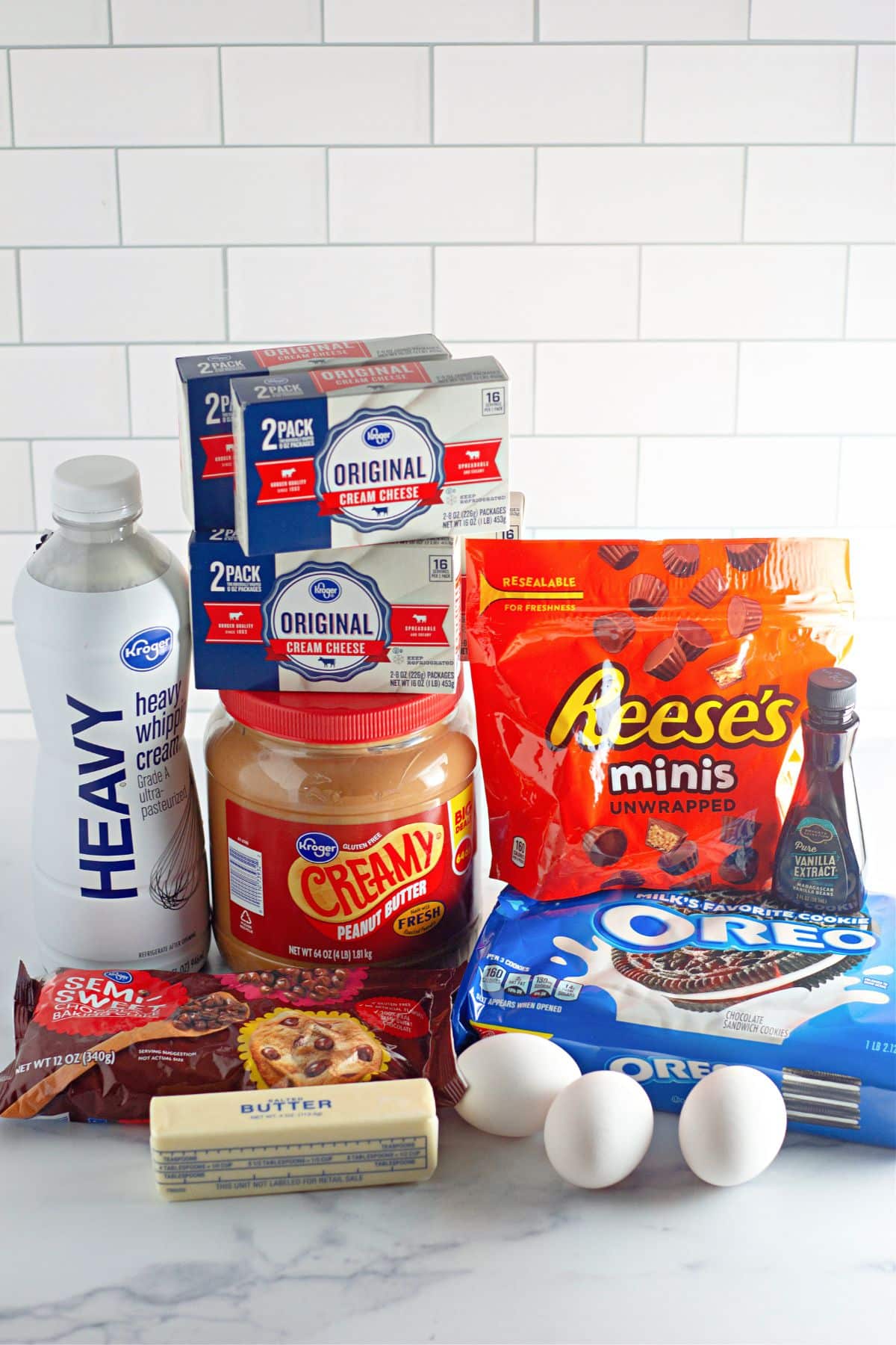container of heavy whipping cream, peanut butter, chocolate chips, butter, cream cheese, reese's minis, vanilla extract, oreo cookies, and eggs.