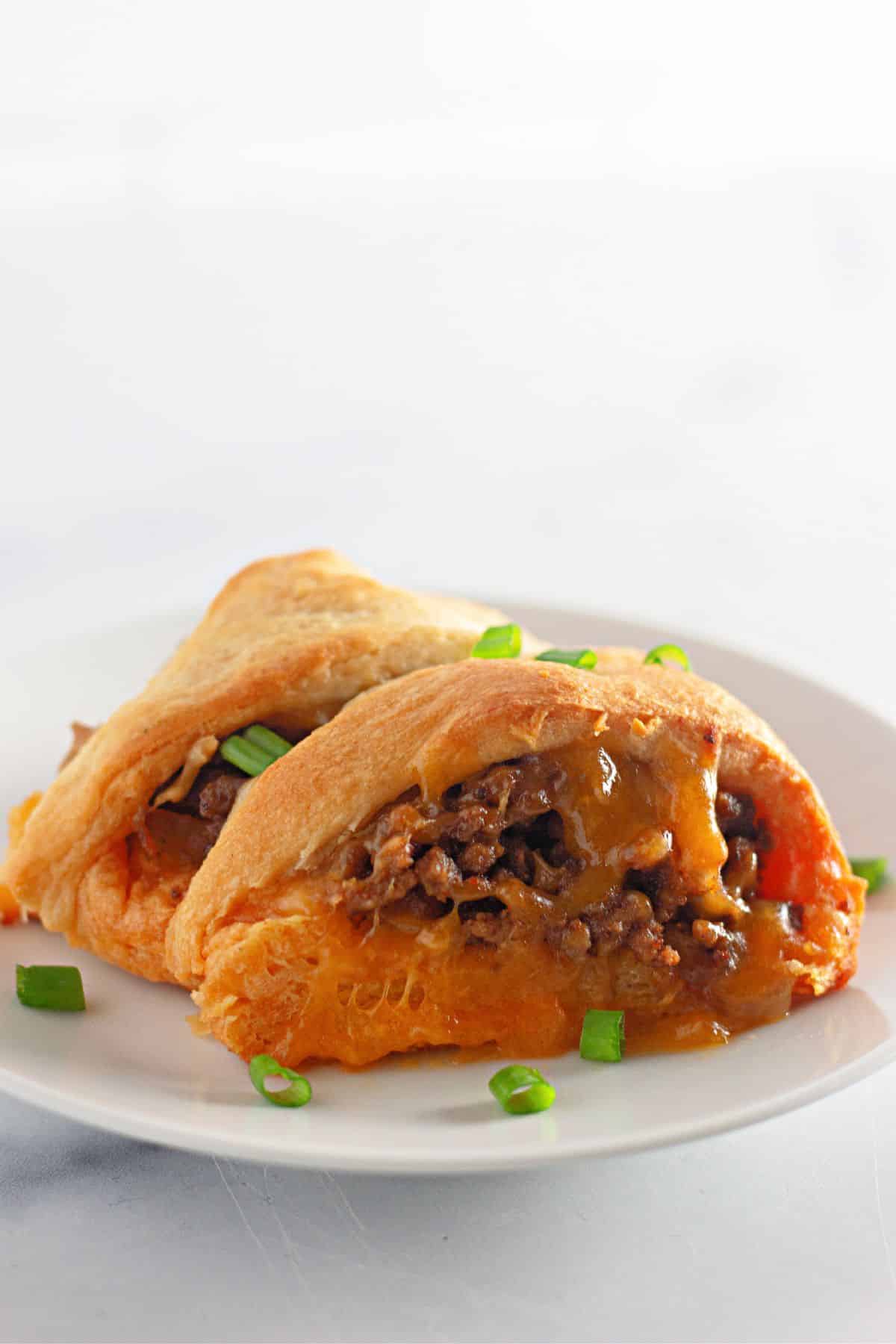 two slices of taco crescent ring on a plate.