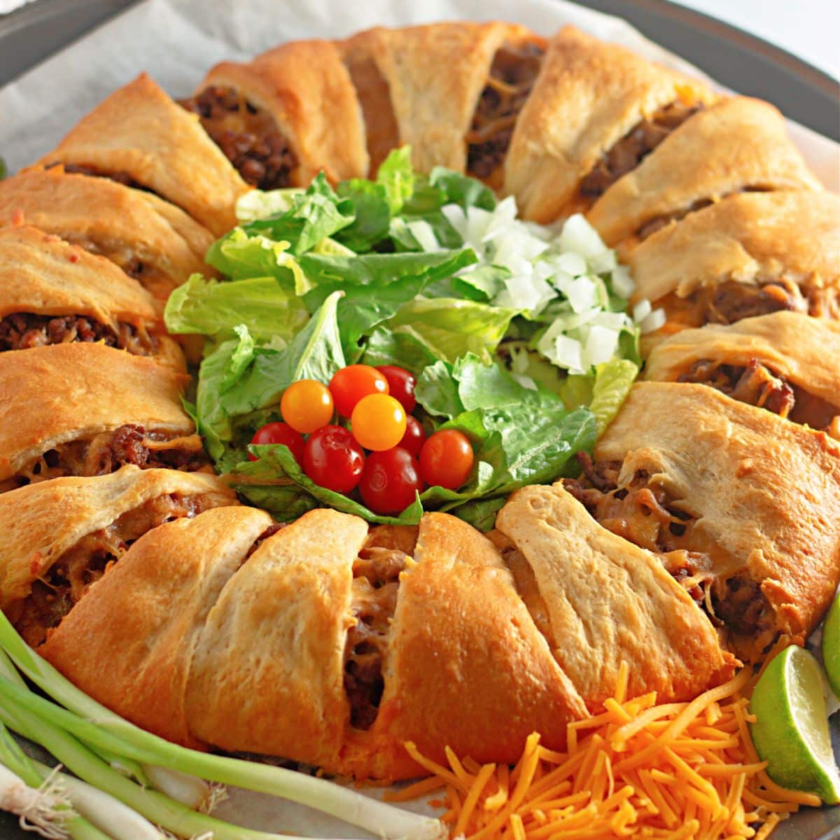 uncut taco crescent ring on a parchment lined baking sheet.