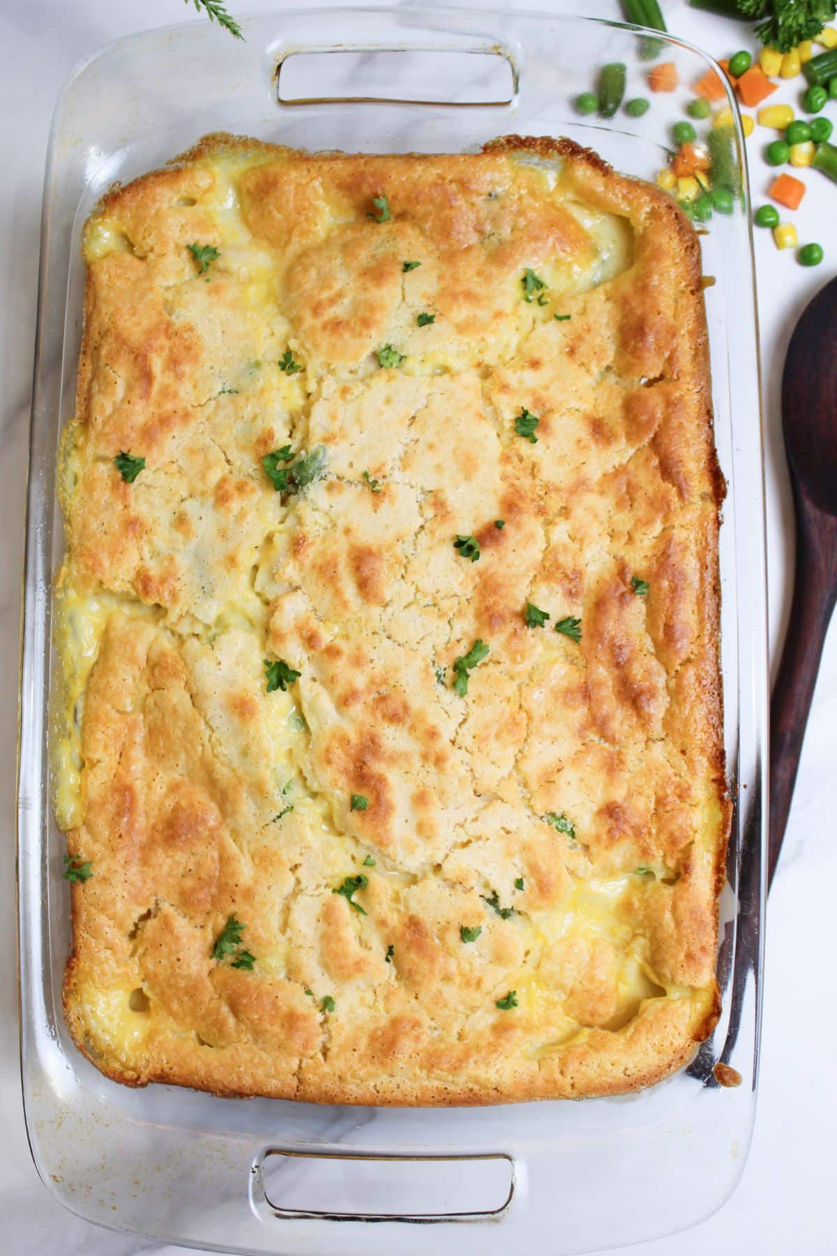 uncut chicken cobbler in a glass baking dish.