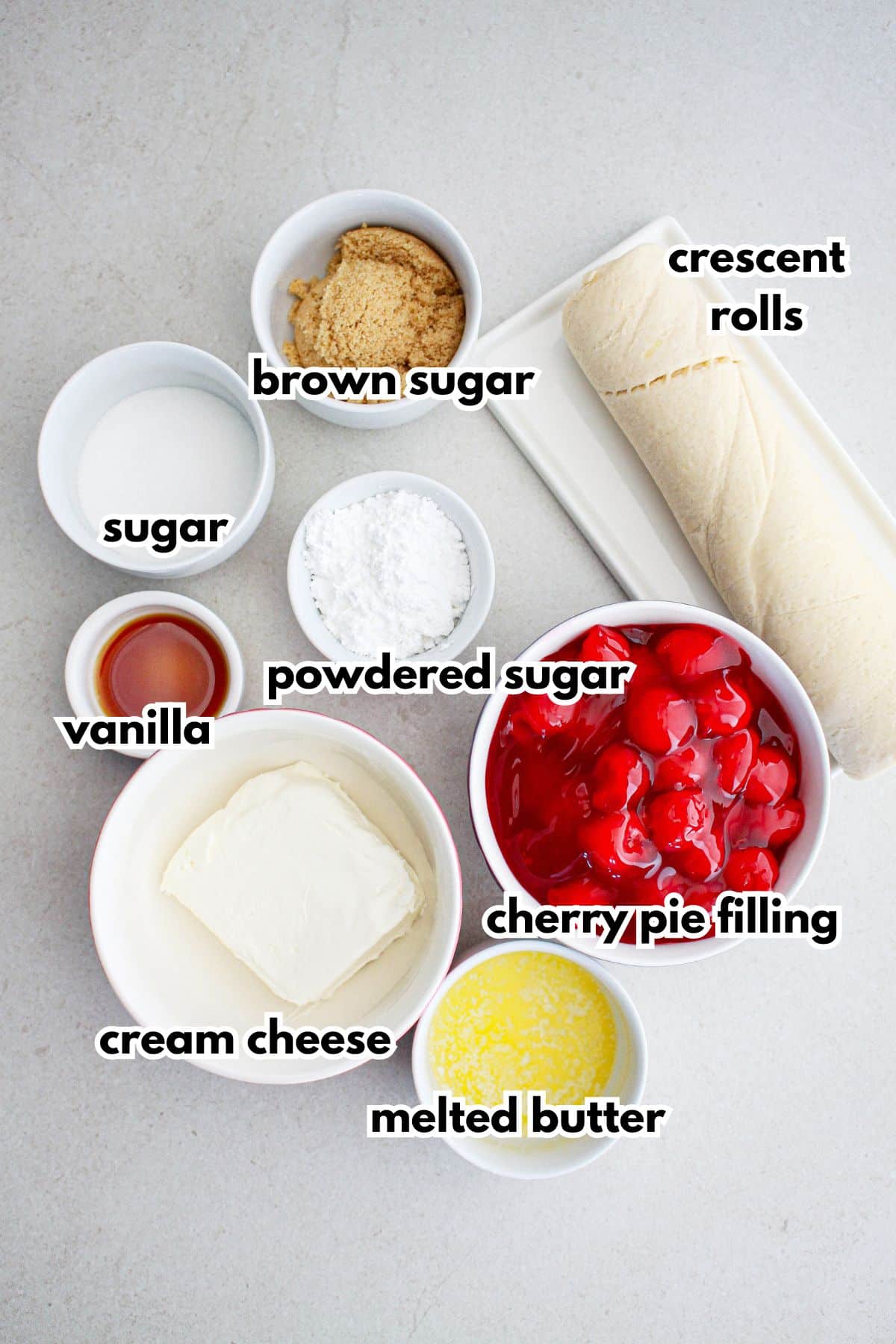 bowls of brown sugar, crescent rolls, sugar, powdered sugar, vanilla, cream cheese, melted butter, and cherry pie filling.