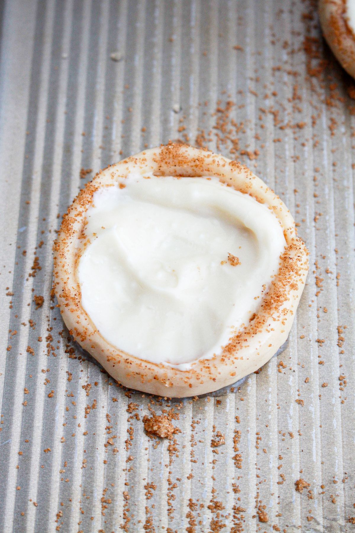 cream cheese being added on top of a crescent roll.