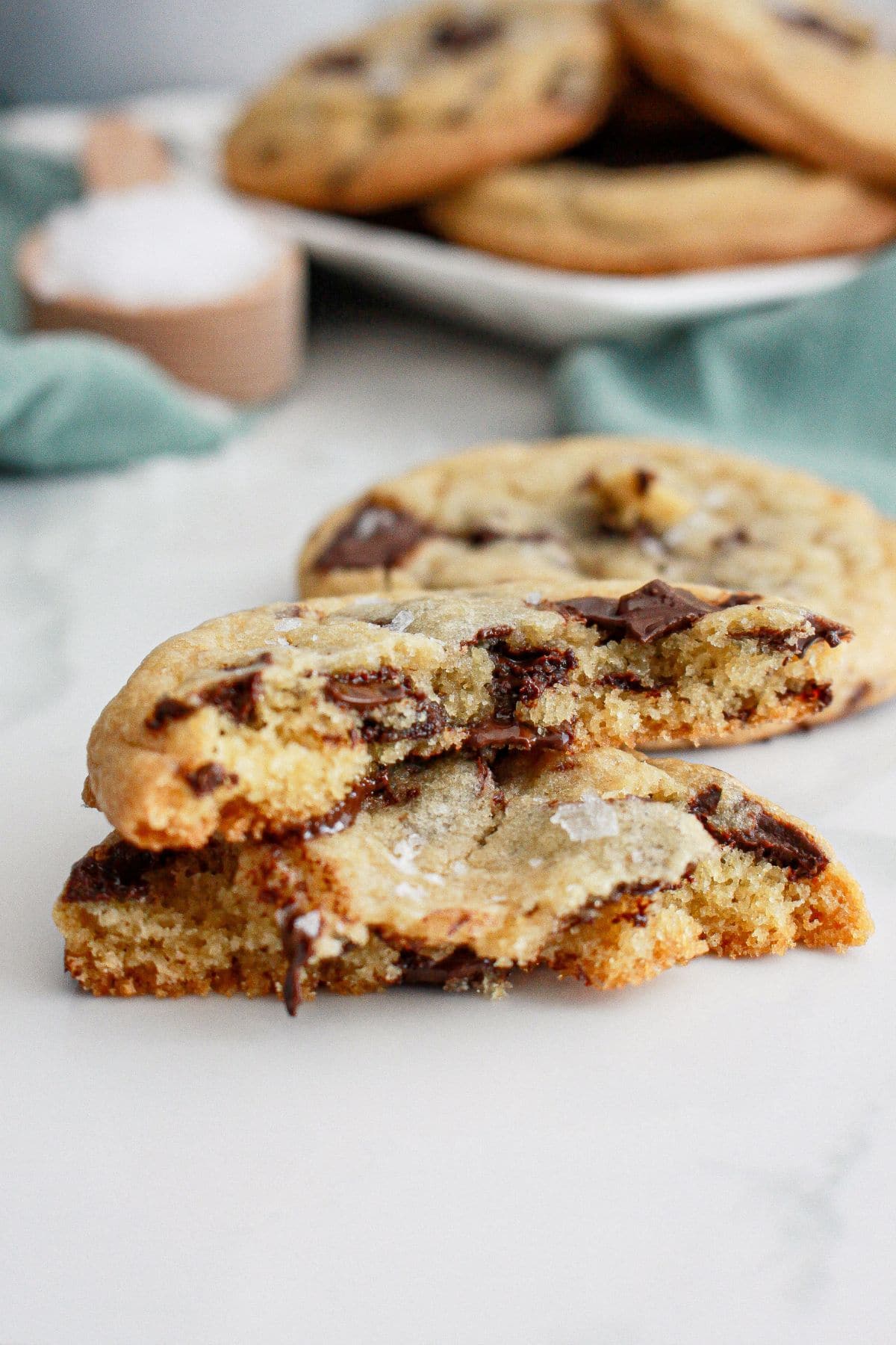 chocolate chunk sea salt cookie broken in half on a counter.