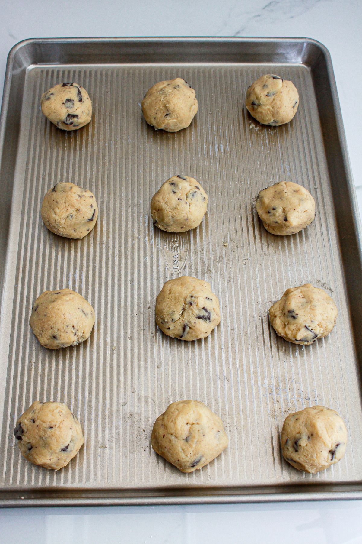 cookie dough balls on a baking sheet.
