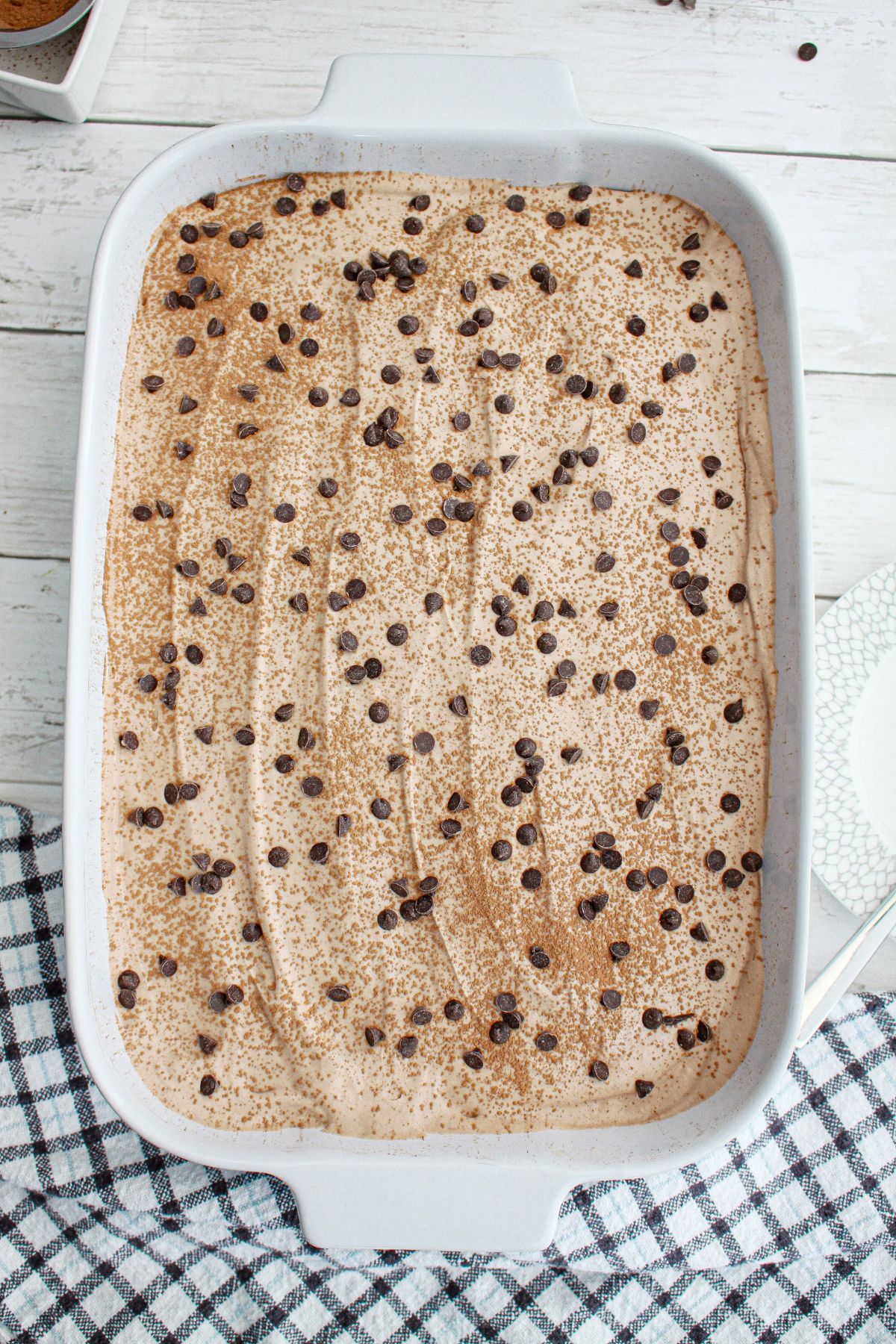 uncut chocolate tres leches cake in a baking dish.