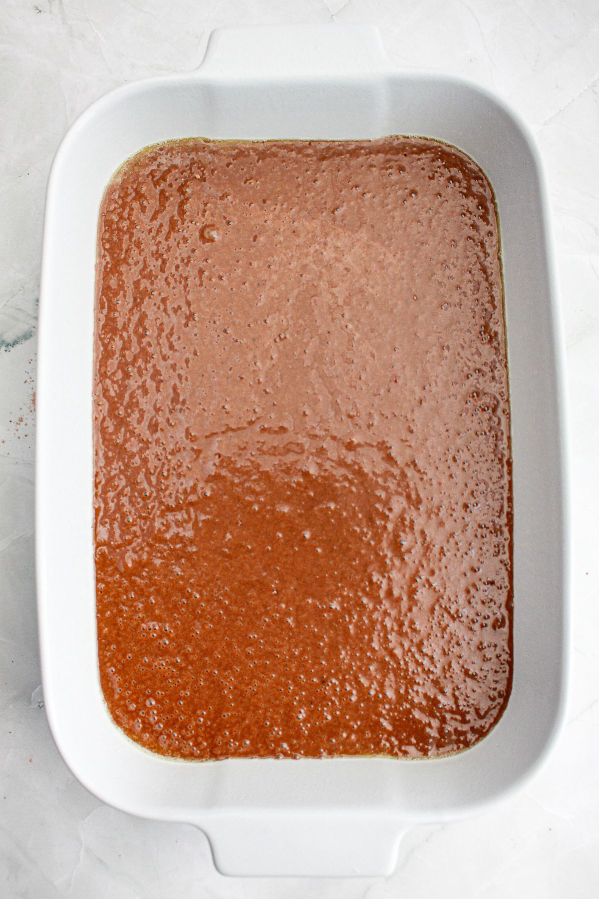 cake batter being poured into a baking dish.