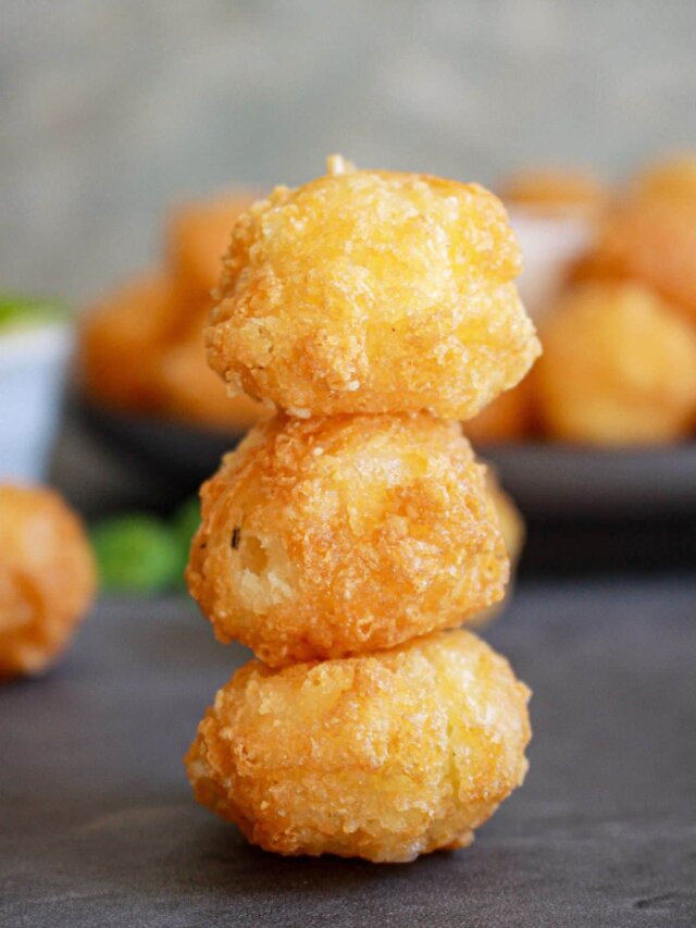 three fried cheese bites stacked on top of each other on a counter.