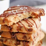 five pieces of espresso shortbread stacked on top of each other with a bite missing from the top one.