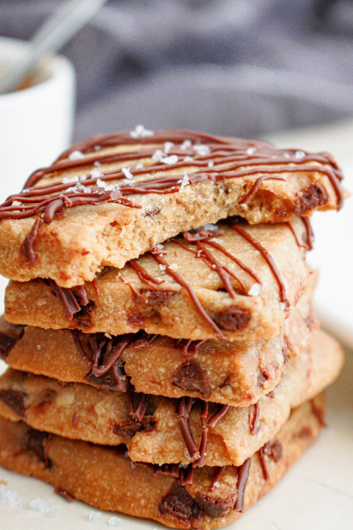 five pieces of espresso shortbread stacked on top of each other with a bite missing from the top one.