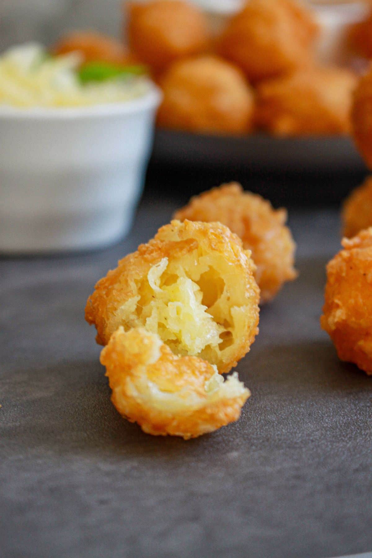 fried cheese bite broken in half on a counter.