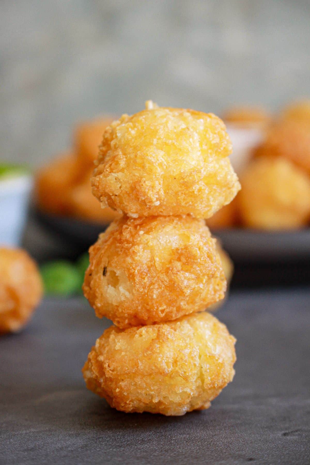 three fried cheese bites stacked on top of each other on a counter.