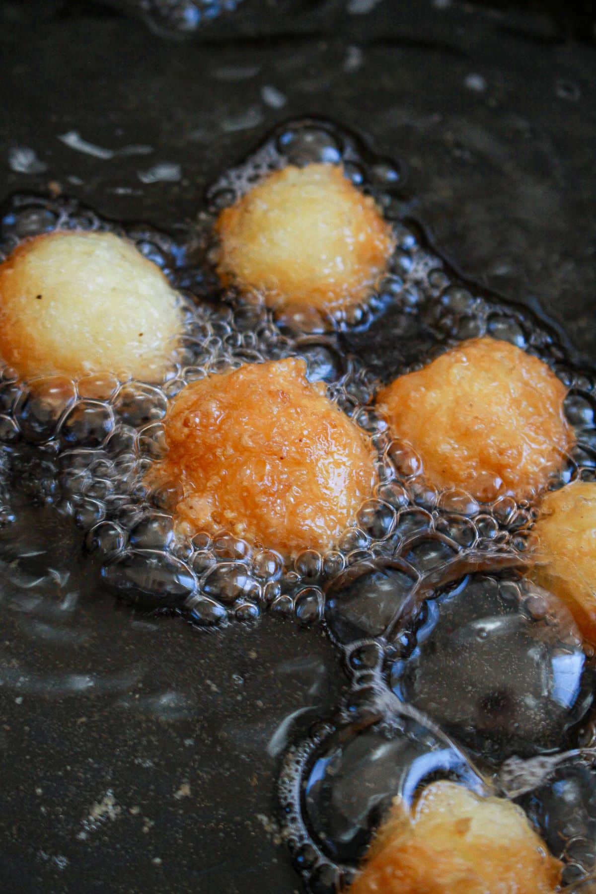 cheese bites being fried in oil.