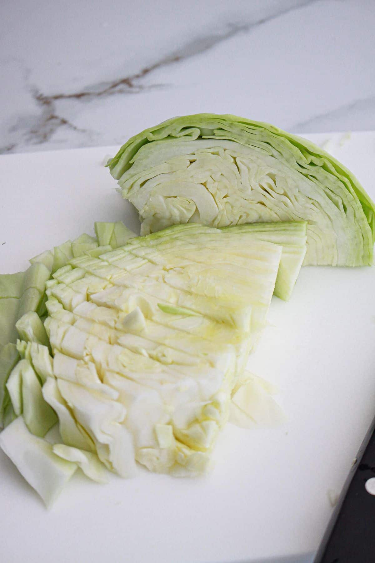 cabbage being chopped on a cutting board.