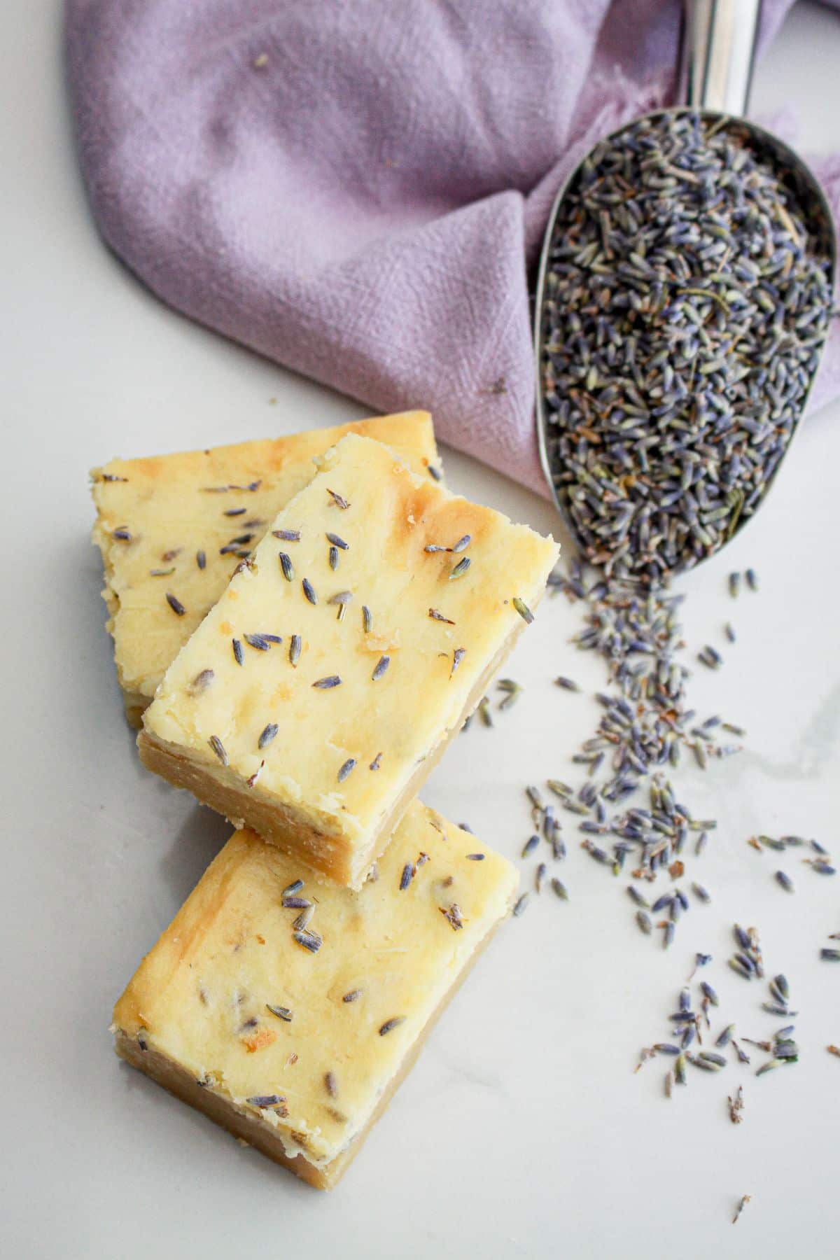 three lemon cheesecake bars on a counter.