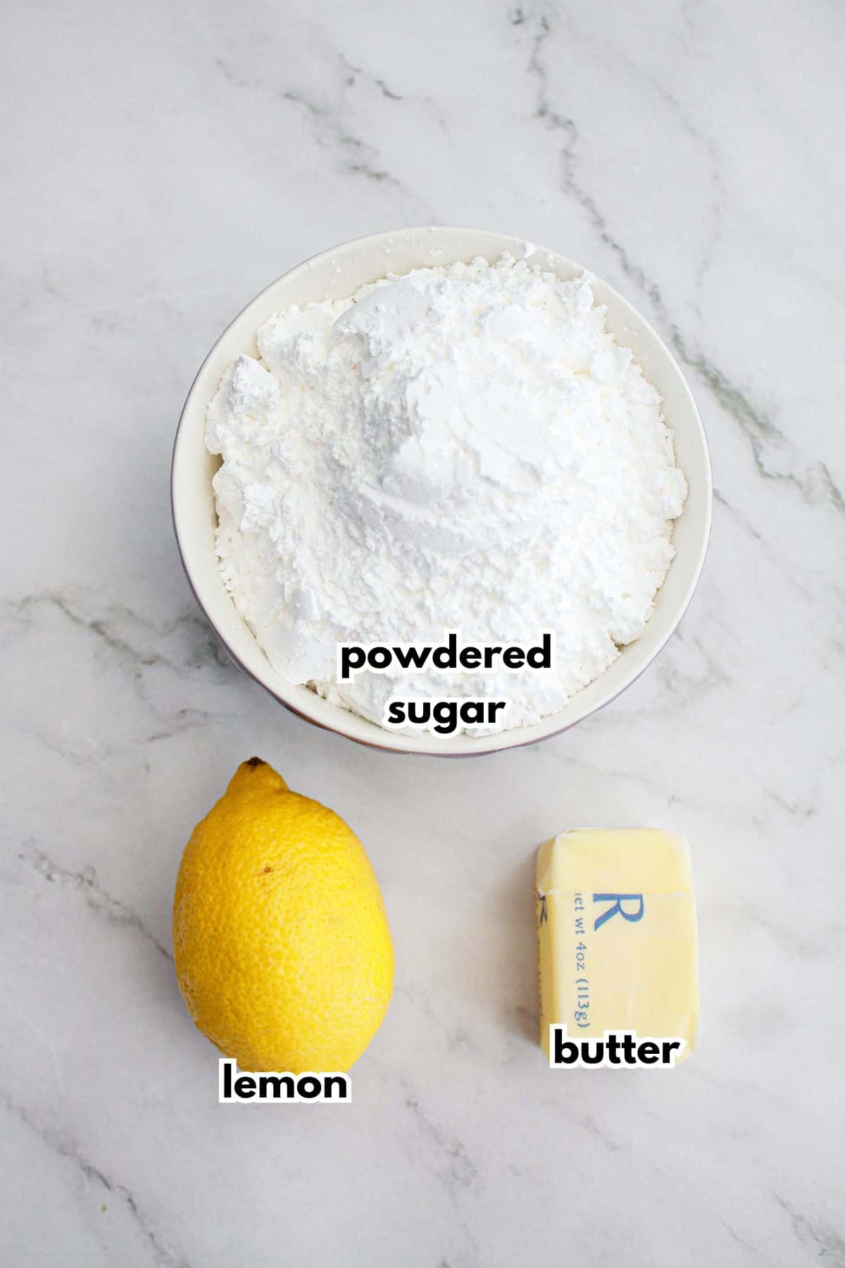 bowls of powdered sugar, lemon, and butter on a counter.