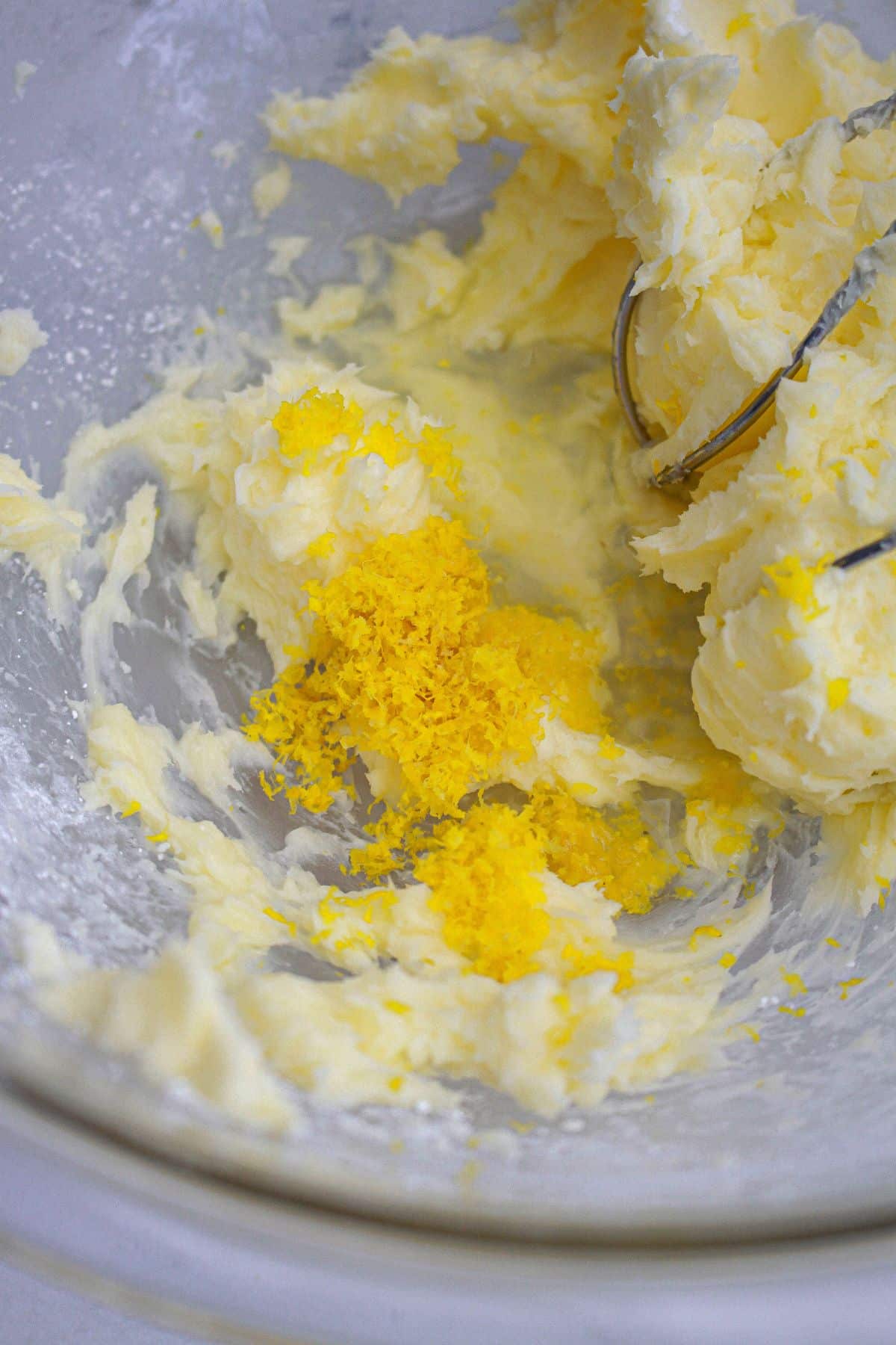lemon zest being added to cookie dough with a hand mixer.