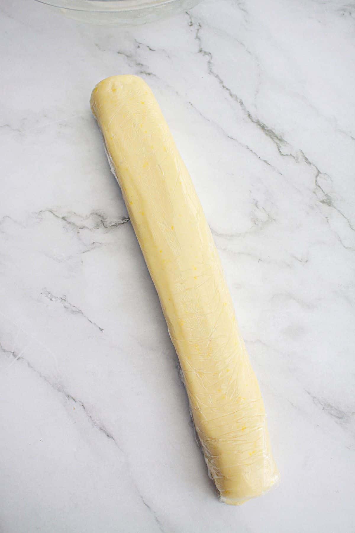 roll of cookie dough wrapped in plastic wrap ready for the fridge.