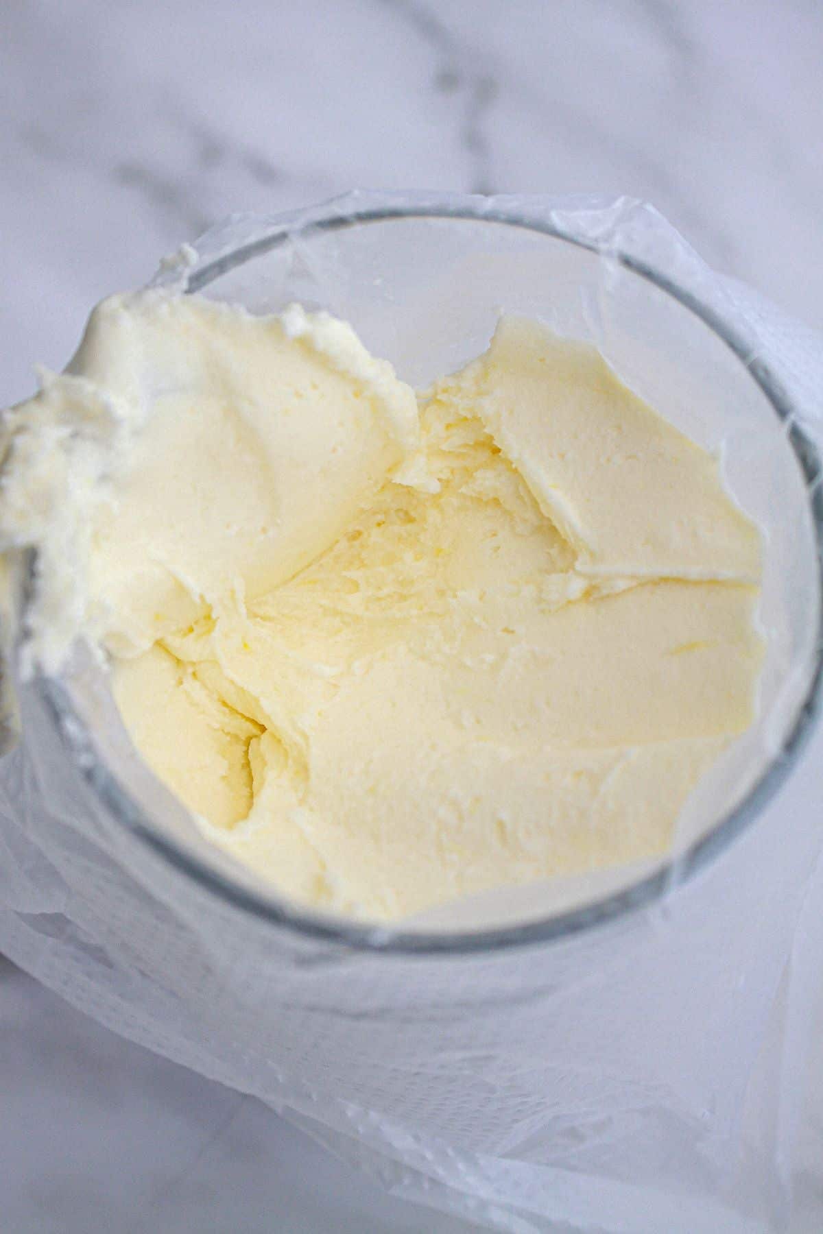 frosting being added to a piping bag in a glass.