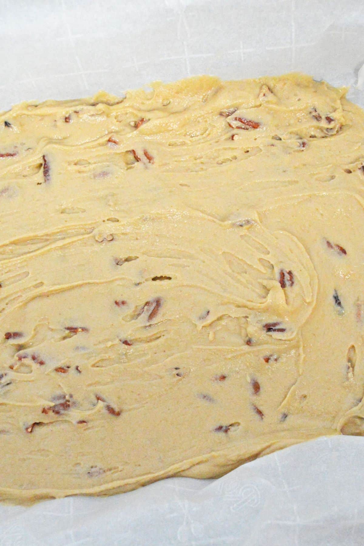 maple pecan blondie dough in a parchment lined baking sheet.
